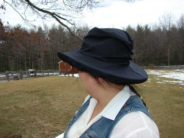 Boston Scarlet showing the black waterproof hat cover over her straw hat.